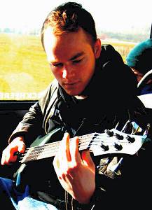 Portrait of Samuel Faict playing guitar.