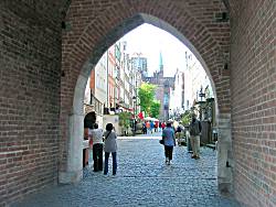 The main pedestrian street in Gdansk through an arched gateway.