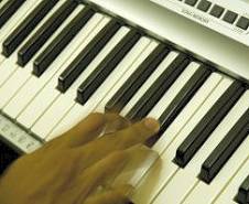 Photo of fingers on an organ keyboard.